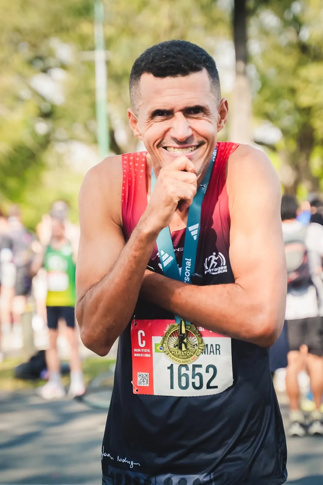 O atleta de elite Joscimar Rodrigues sorrindo com a medalha após concluir sua primeira corrida internacional em Buenos Aires